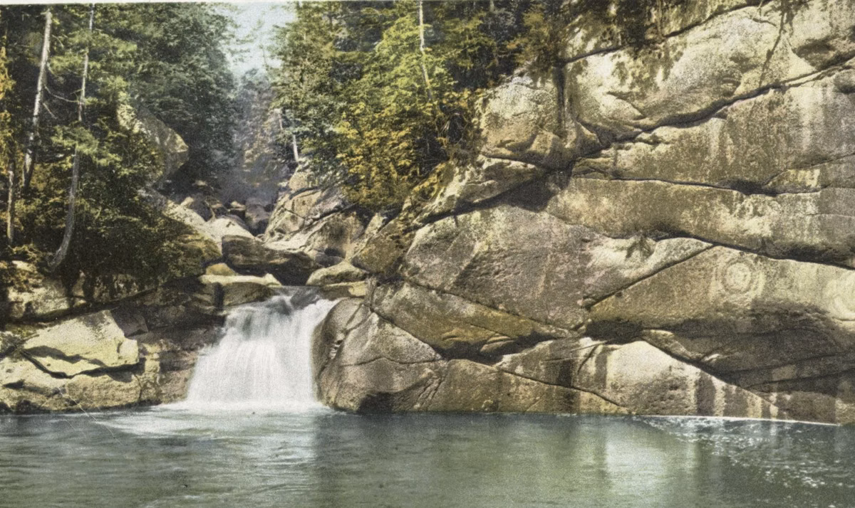 Early 1900s postcard of the Pool, a deep basin below granite cliffs near the Flume