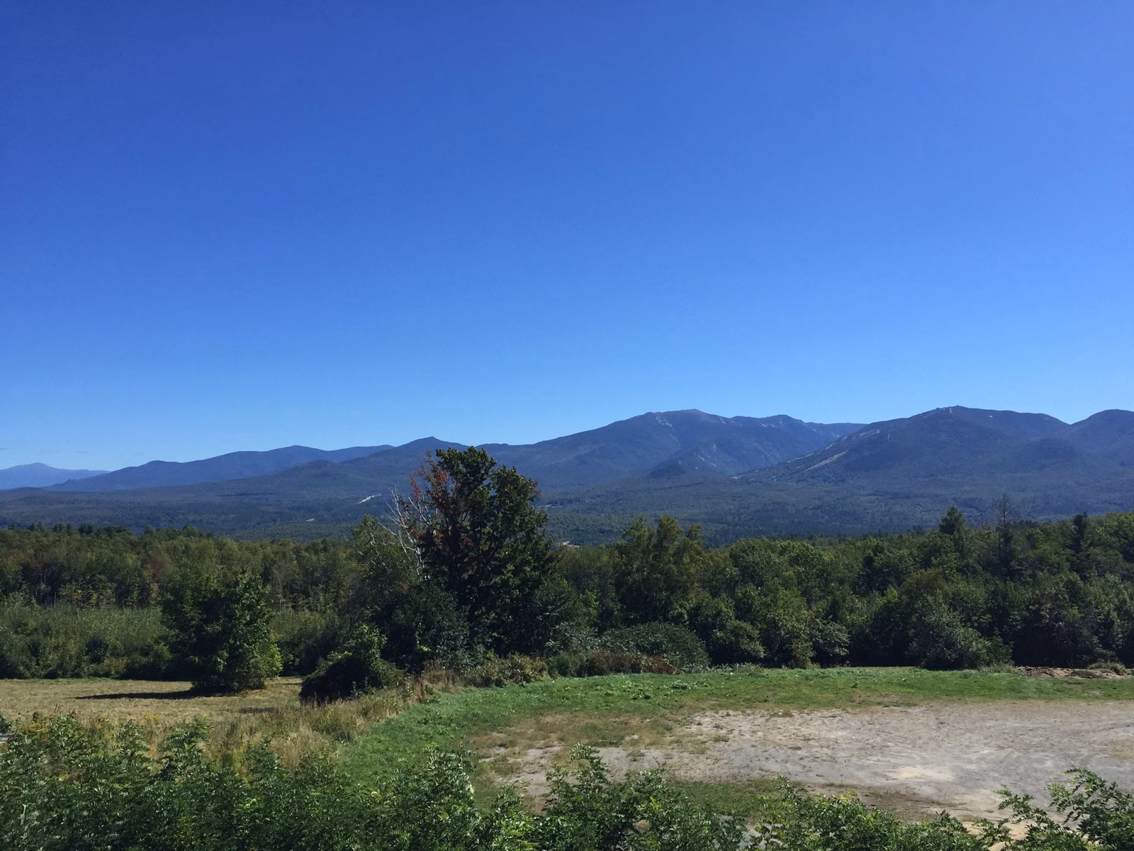 Clear blue sky over the Franconia Range seen across open land